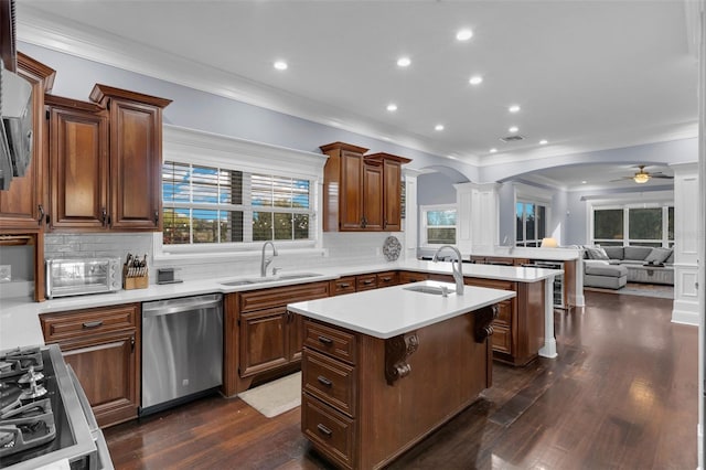 kitchen with an island with sink, a kitchen breakfast bar, dishwasher, and sink