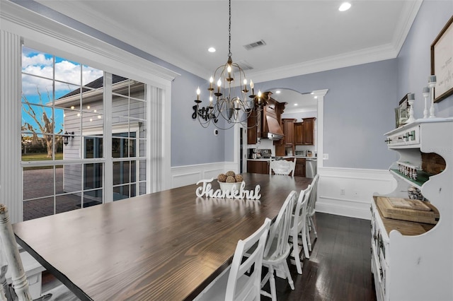 dining space with ornamental molding, dark hardwood / wood-style flooring, and a chandelier