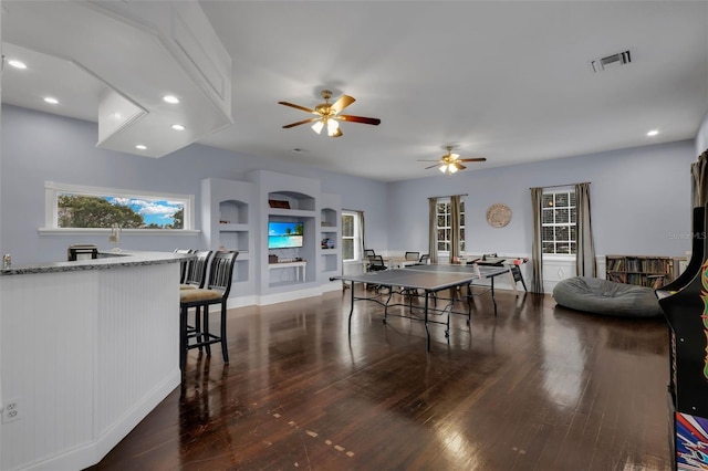 dining space featuring built in shelves and dark wood-type flooring