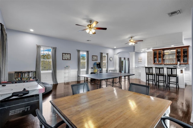 dining room featuring ceiling fan, dark hardwood / wood-style flooring, and ornate columns