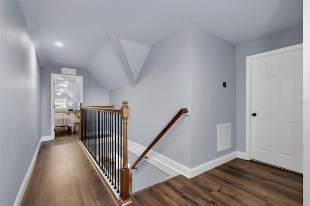 corridor featuring dark wood-type flooring and vaulted ceiling