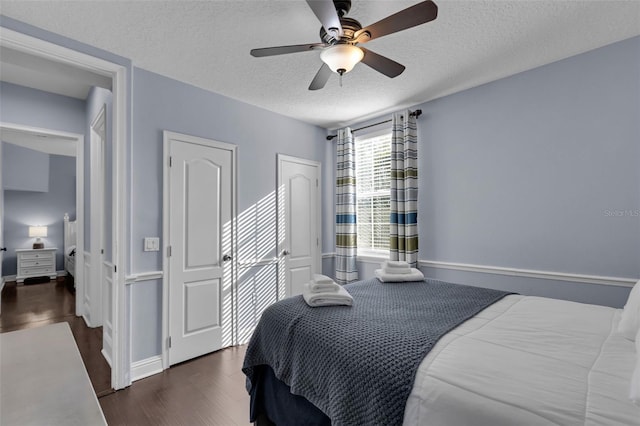 bedroom featuring dark wood-type flooring, ceiling fan, and a textured ceiling