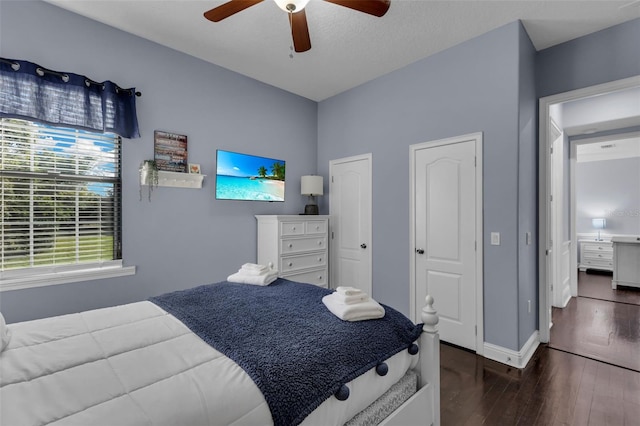 bedroom with multiple closets, ceiling fan, and dark hardwood / wood-style floors