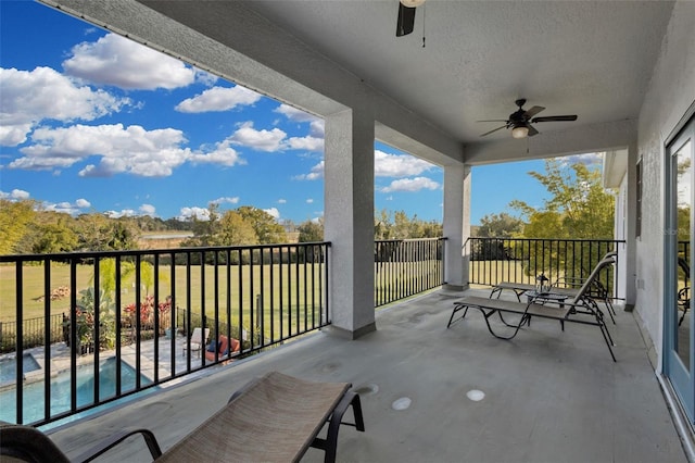 view of patio / terrace featuring ceiling fan, a fenced in pool, and a balcony