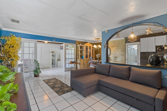 tiled living room with crown molding and a chandelier