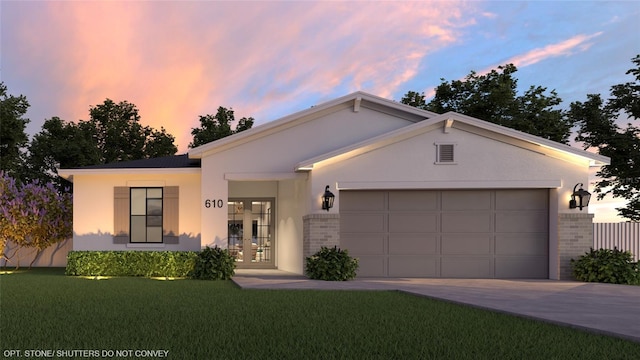 ranch-style home with a yard, a garage, and french doors