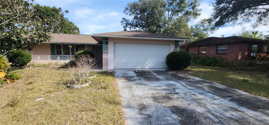 single story home with a garage, a front yard, and covered porch