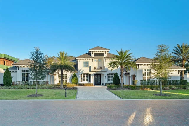 mediterranean / spanish home with a balcony and a front yard