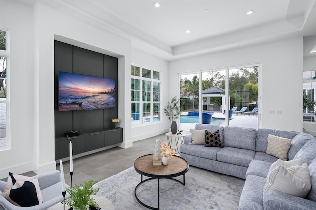 living room with a raised ceiling and light tile patterned floors