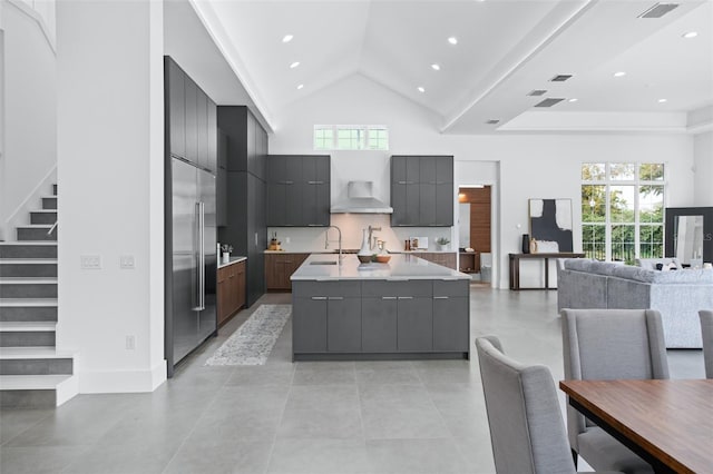 kitchen with a healthy amount of sunlight, high vaulted ceiling, a large island, and sink