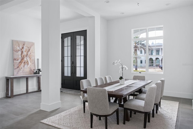 dining space featuring concrete floors and french doors