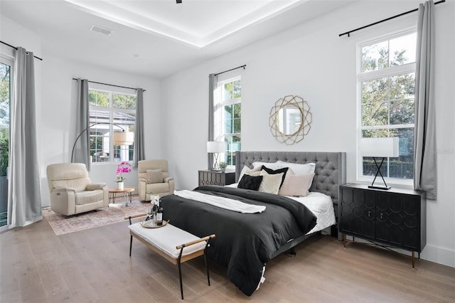 bedroom featuring multiple windows and light wood-type flooring