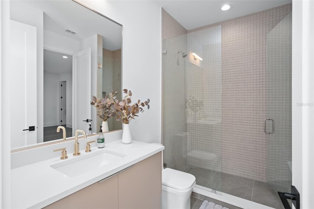 bathroom featuring vanity, toilet, and a shower with shower door