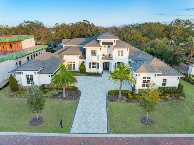 view of front of property featuring a front yard and a balcony