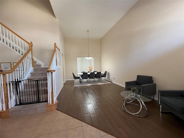 entrance foyer with an inviting chandelier, a towering ceiling, and light hardwood / wood-style flooring