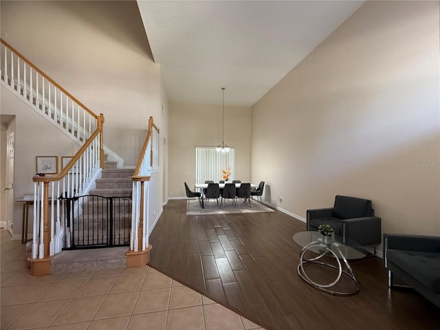 entryway with a notable chandelier, light wood-type flooring, and a high ceiling