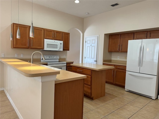 kitchen featuring light tile patterned floors, pendant lighting, white appliances, and kitchen peninsula