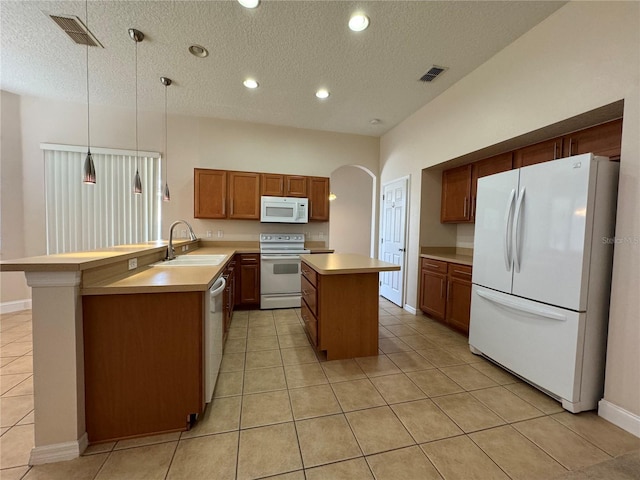 kitchen featuring sink, hanging light fixtures, kitchen peninsula, a kitchen island, and white appliances