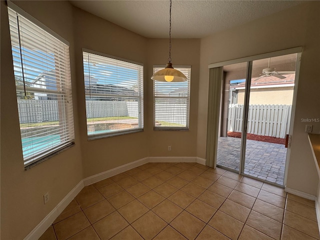 unfurnished dining area with light tile patterned floors and a textured ceiling