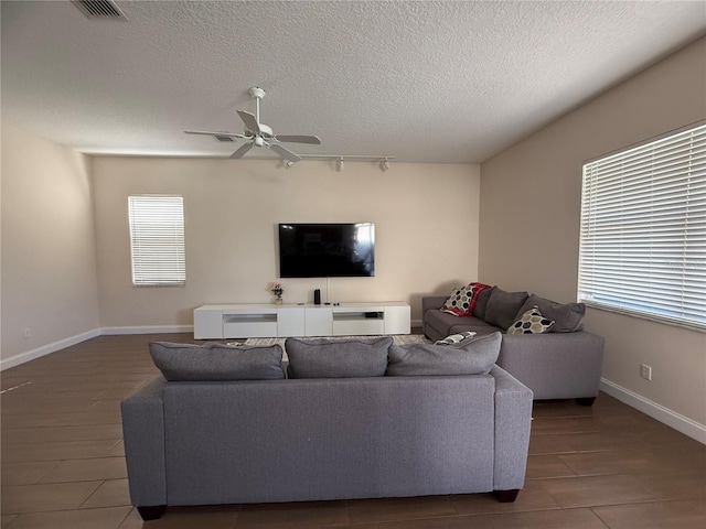 living room with a textured ceiling, track lighting, and ceiling fan