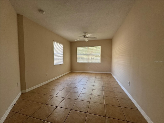 unfurnished room with ceiling fan, a textured ceiling, and light tile patterned floors