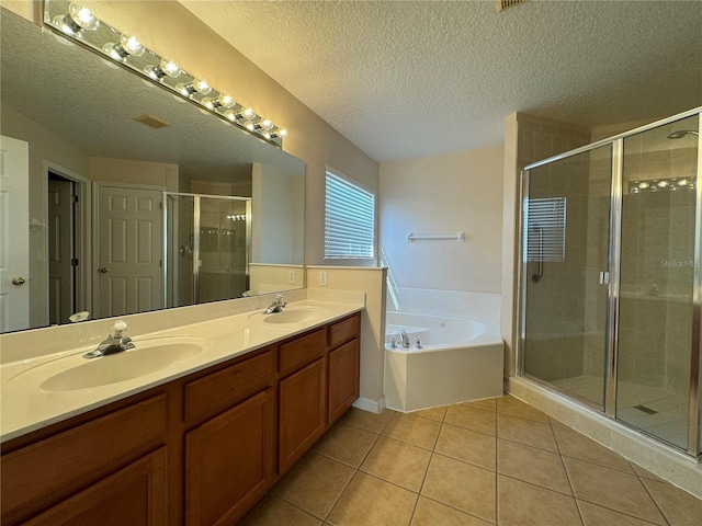 bathroom featuring vanity, independent shower and bath, tile patterned flooring, and a textured ceiling