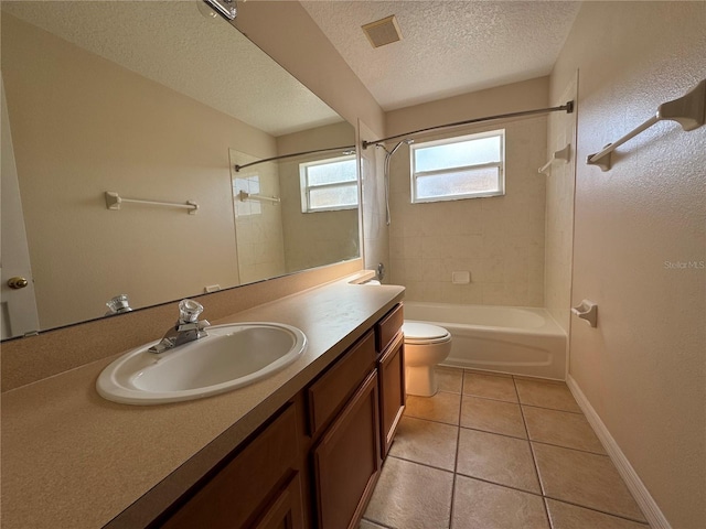 full bathroom featuring tiled shower / bath, tile patterned flooring, vanity, toilet, and a textured ceiling