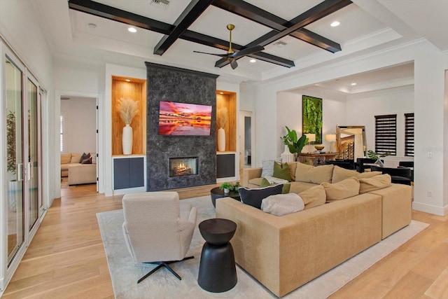 living room with a premium fireplace, coffered ceiling, and light wood-type flooring