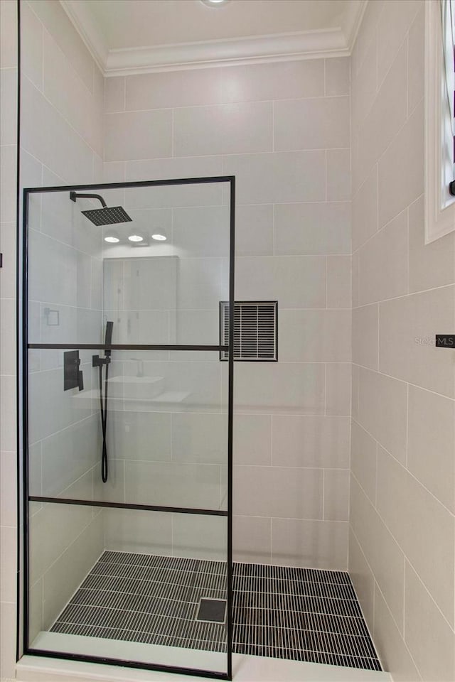 bathroom featuring crown molding and a tile shower