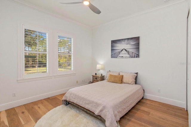 bedroom featuring hardwood / wood-style flooring, ornamental molding, and ceiling fan