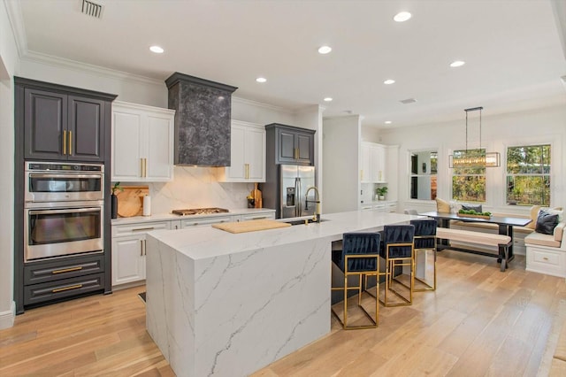 kitchen with white cabinetry, stainless steel appliances, and a large island