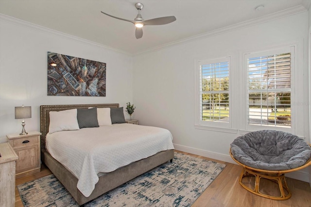 bedroom with hardwood / wood-style flooring, crown molding, and ceiling fan