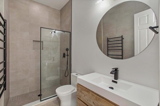 bathroom with vanity, tiled shower, radiator, and toilet