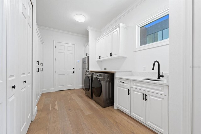 10416 Pocket Ln, Orlando, FL 32836 - washroom featuring separate washer and dryer, cabinet space, light wood finished floors, and ornamental molding
