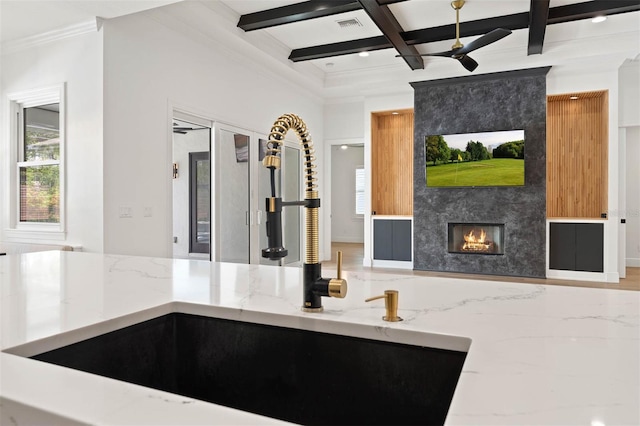 10416 Pocket Ln, Orlando, FL 32836 - kitchen with ceiling fan, light stone countertops, coffered ceiling, a fireplace, and beamed ceiling