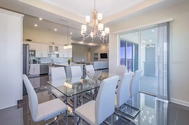 dining area with dark tile patterned floors, sink, and a chandelier