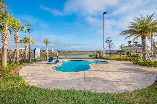 view of pool featuring a water view and a patio area