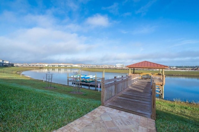 dock area featuring a water view, a gazebo, and a lawn