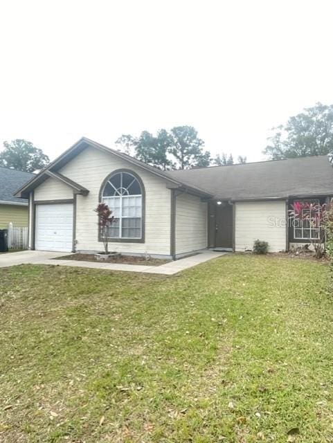 single story home with a garage and a front lawn