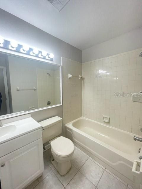 full bathroom featuring vanity, tile patterned floors, toilet, and tiled shower / bath