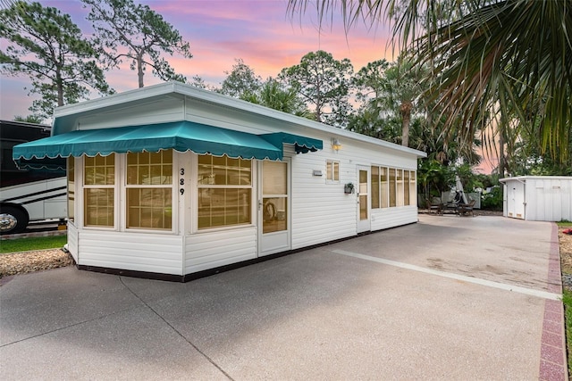 property exterior at dusk featuring a patio