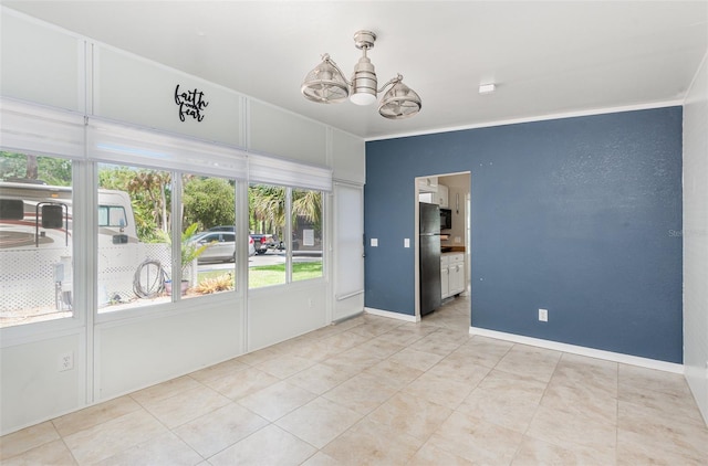 empty room featuring a notable chandelier, light tile patterned floors, and ornamental molding