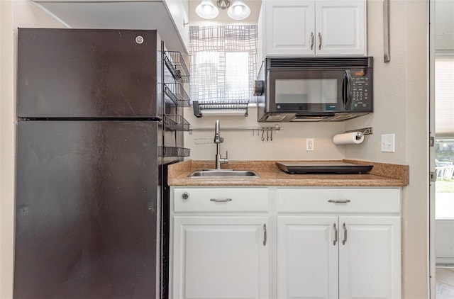 kitchen featuring white cabinetry, sink, and black appliances