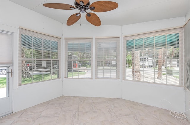 unfurnished sunroom with ceiling fan