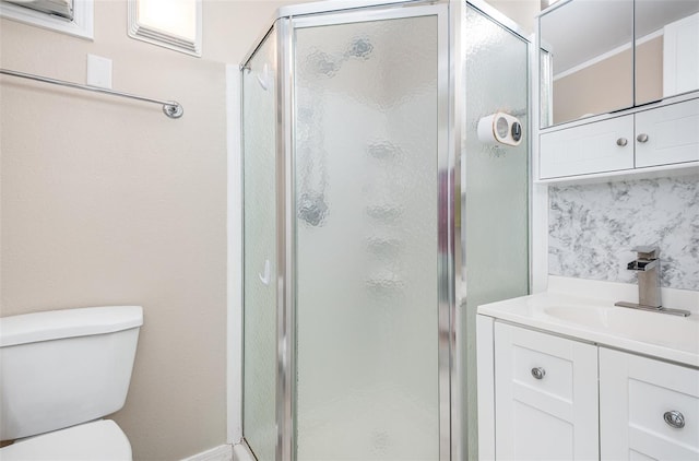 bathroom with vanity, a shower with shower door, and toilet