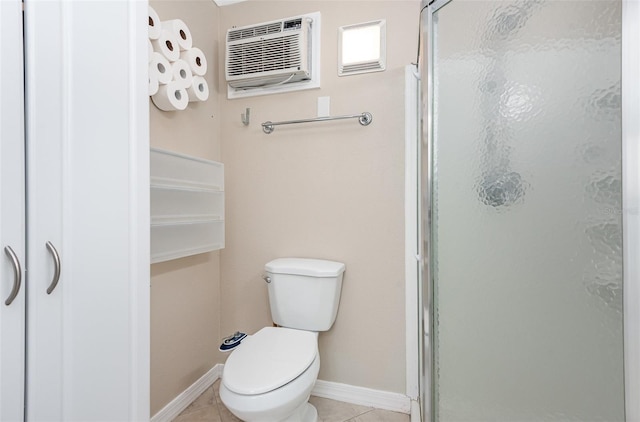 bathroom with tile patterned flooring, a shower with shower door, and toilet