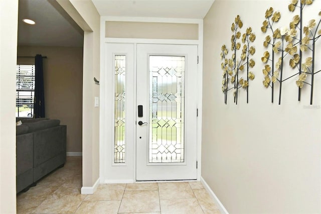 doorway to outside with light tile patterned floors