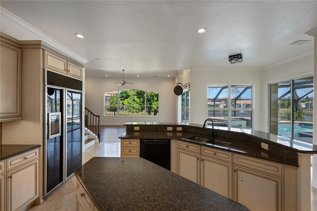 kitchen with dark stone countertops, sink, black appliances, and a kitchen island