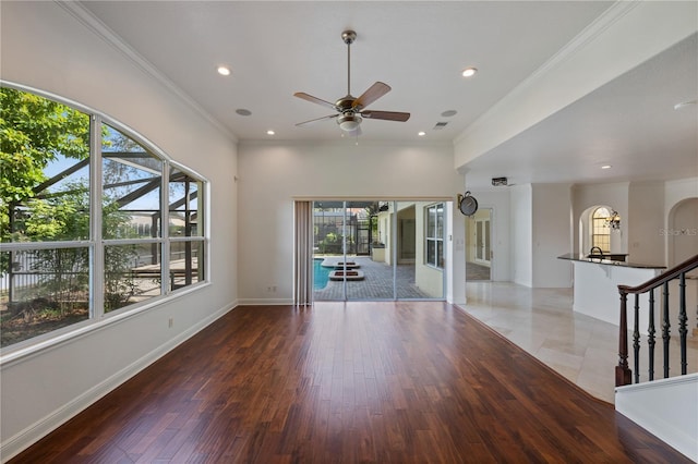 unfurnished living room featuring crown molding, ceiling fan, and dark hardwood / wood-style floors