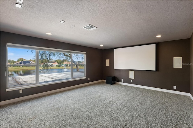 carpeted cinema featuring a textured ceiling